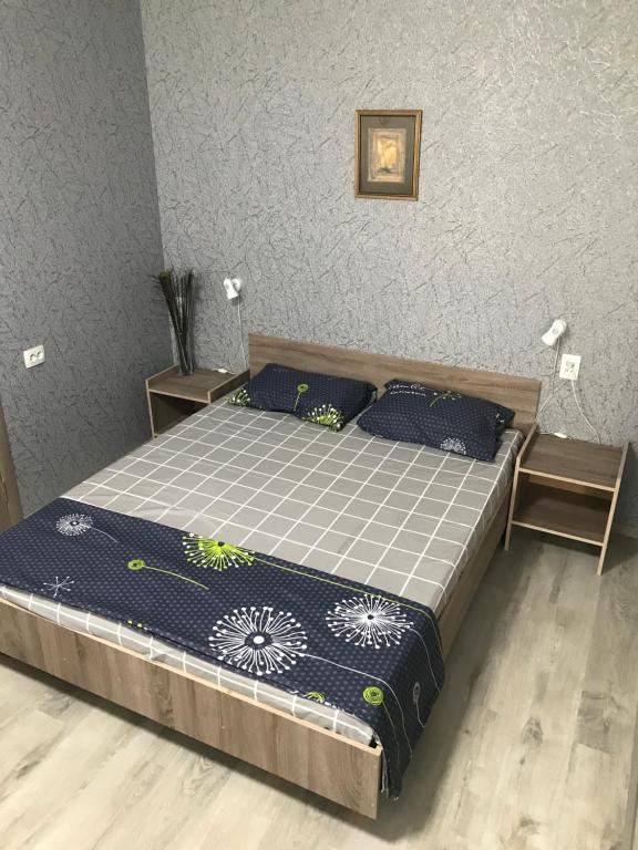 1 dormitorio con 1 cama grande con almohadas azules en Apartments O.Polya ( Kirova) 106, en Dnipro