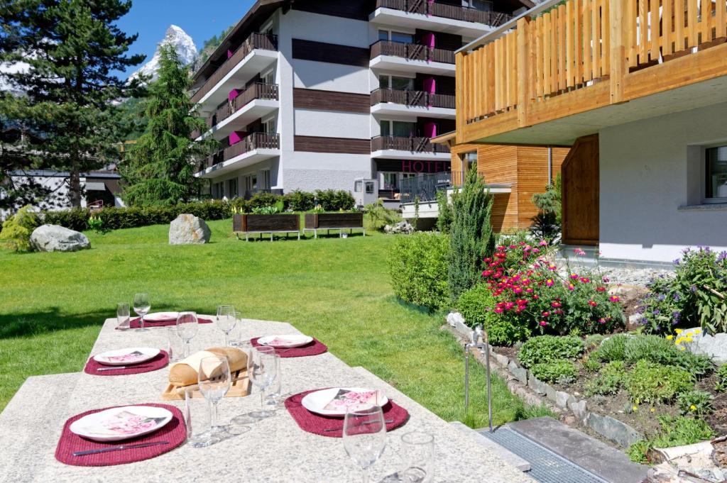 einen Tisch mit Tellern und Gläsern im Hof in der Unterkunft Arca Aparthotel &amp; Spa in Zermatt