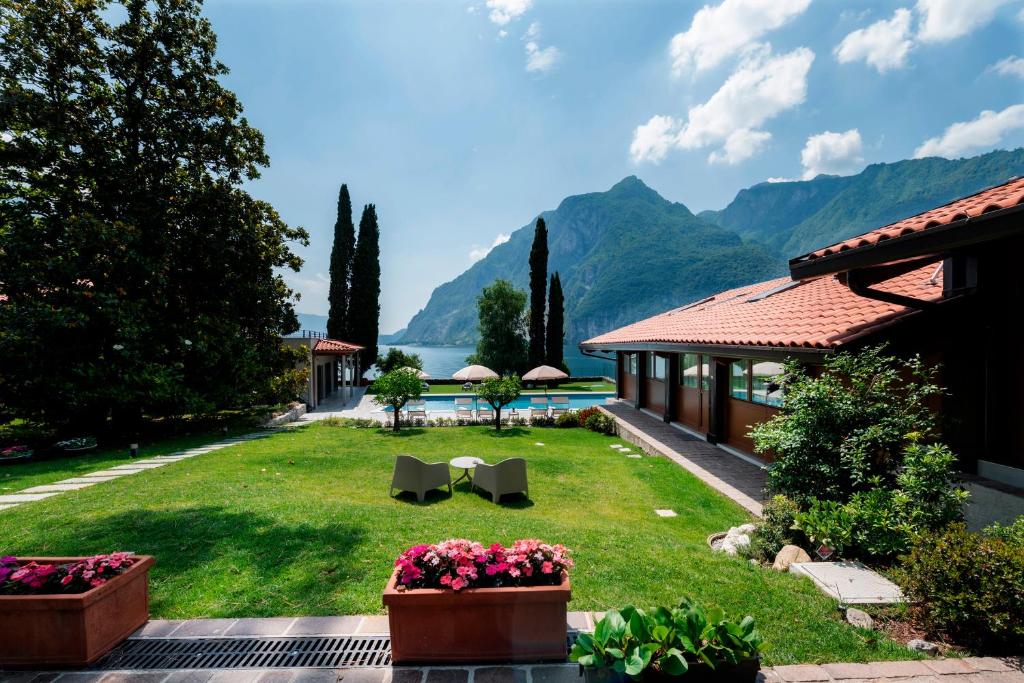 een tuin met een huis en bergen op de achtergrond bij Villa Onedo in Abbadia Lariana