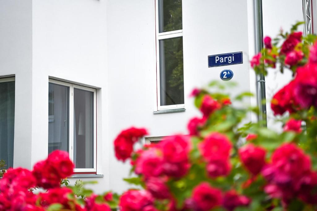 a bunch of red flowers in front of a white building at Zagorski Apartment 2 in Kuressaare