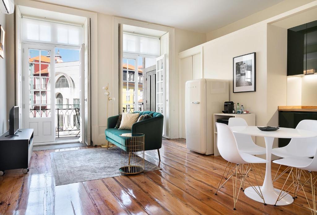 een woonkamer met een tafel en een koelkast bij Historic apartment at Cardosas with balcony in Porto