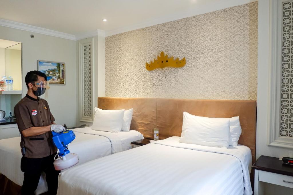 Postel nebo postele na pokoji v ubytování Swiss-Belhotel Lampung