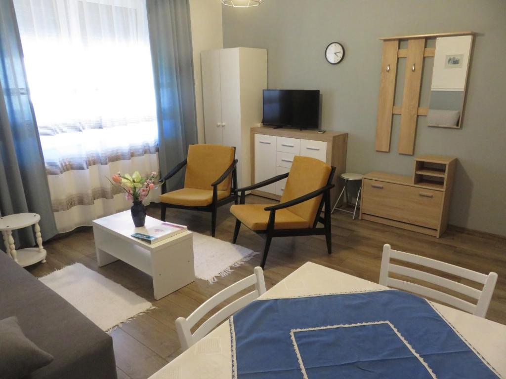 salon z kanapą, krzesłami i telewizorem w obiekcie Kővirág Apartman w Hévízie