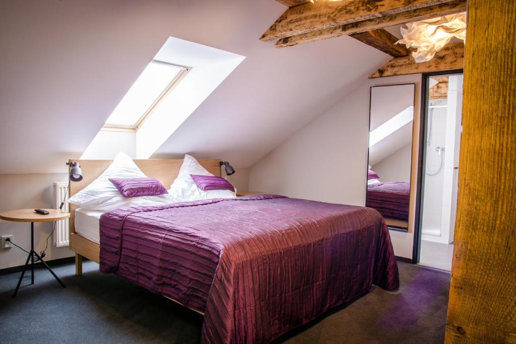 ein Schlafzimmer mit einem großen Bett und einem Spiegel in der Unterkunft Hotel Restaurant Na Návsi in Říčany u Brna