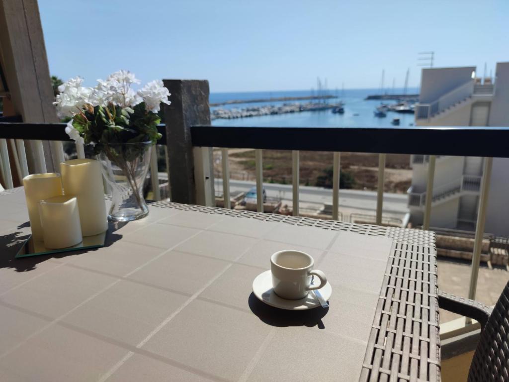 a table with a cup of coffee on a balcony at LiMonello Marzamemi in Marzamemi