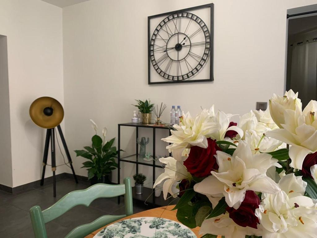 une table avec des fleurs blanches et une horloge sur le mur dans l'établissement Le Pont Kuss, à Strasbourg