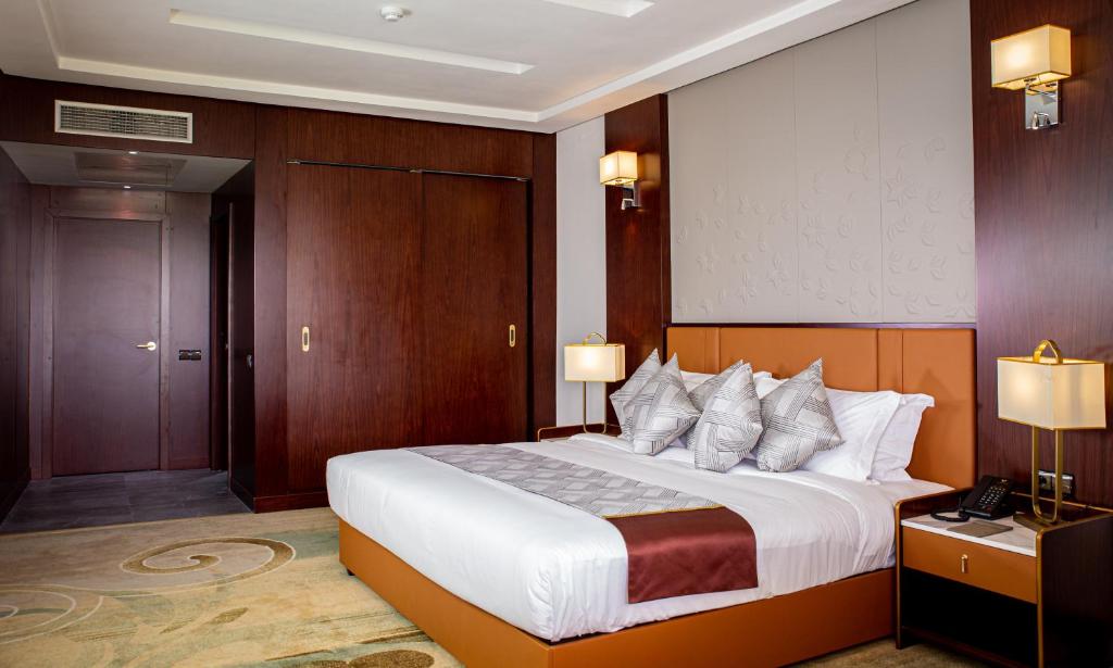 a hotel room with a large bed with wooden walls at Waves Aqua Resort in Kenitra