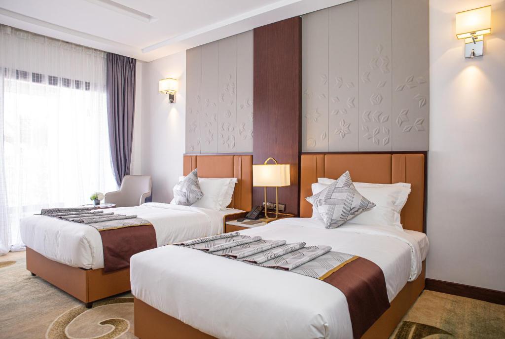 a hotel room with two beds and a window at Waves Aqua Resort in Kenitra