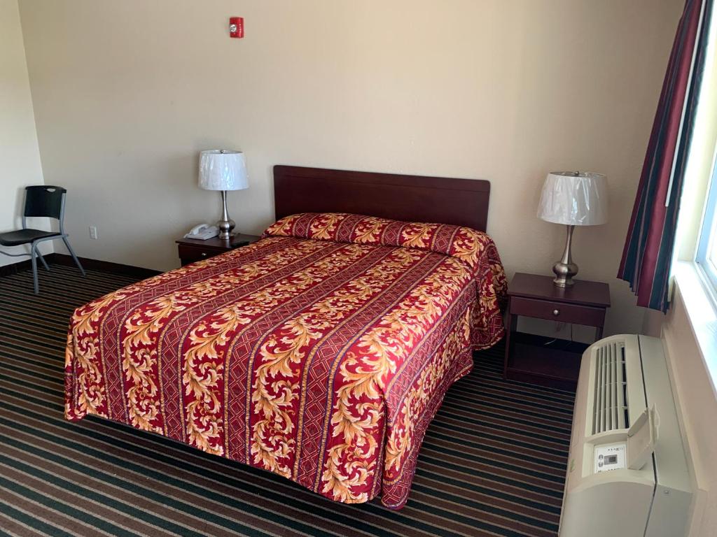 a hotel room with a bed and two lamps at Wayne Motel in Fort Wayne
