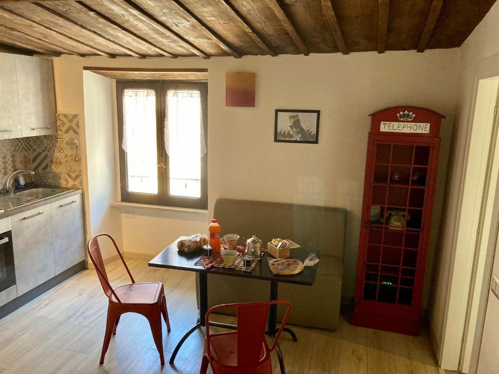 uma cozinha com mesa e cadeiras e um armário vermelho em Viterbo alloggio turistico hipster house em Viterbo