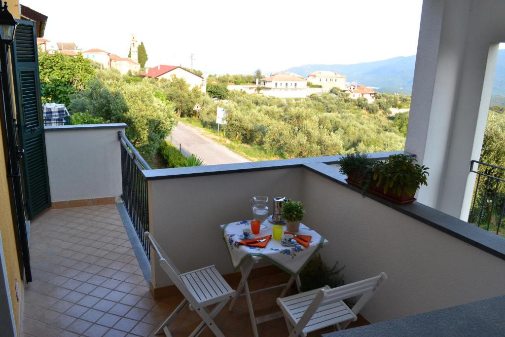 einen Balkon mit einem Tisch und Stühlen in der Unterkunft Casa di Gian in Arnasco