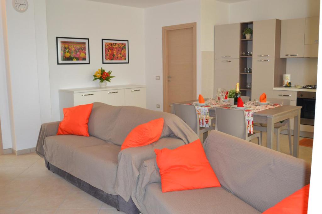 salon z szarą kanapą z pomarańczowymi poduszkami w obiekcie Casa di Gian w mieście Arnasco