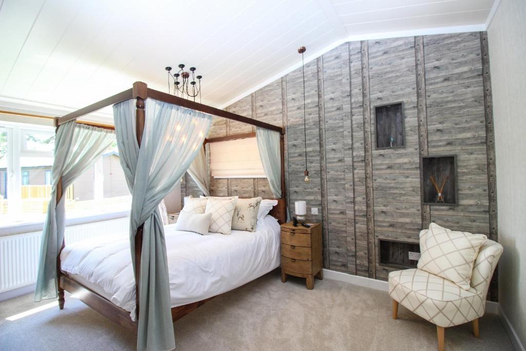 a bedroom with a canopy bed and a fireplace at Hollicarrs - Kingfisher Lodge in York