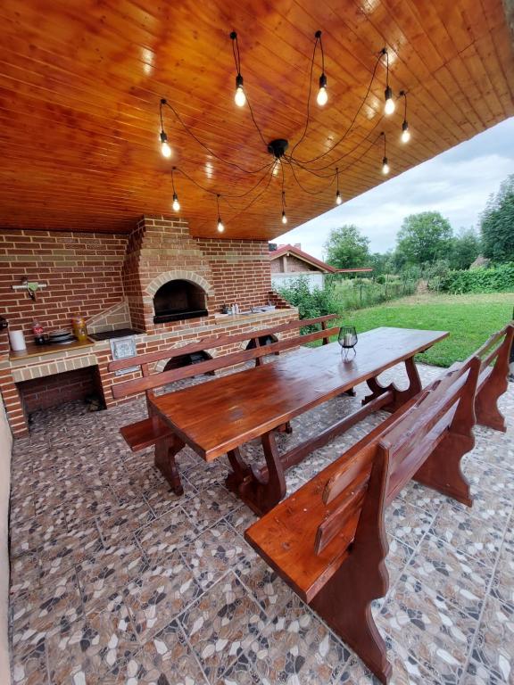 un patio con una gran mesa de madera y bancos en Casa YMY, en Sarmizegetusa