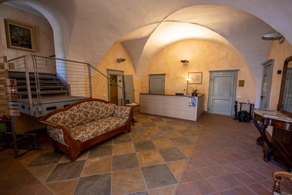a living room with a couch and a staircase at Albergo dell'Academia in Mondovì