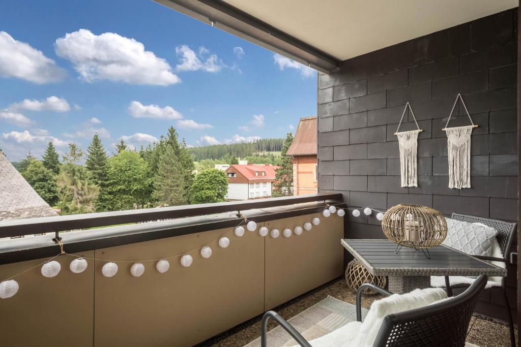 a balcony with a table and a large window at Heimelig im Hirschen App 240 in Schönwald