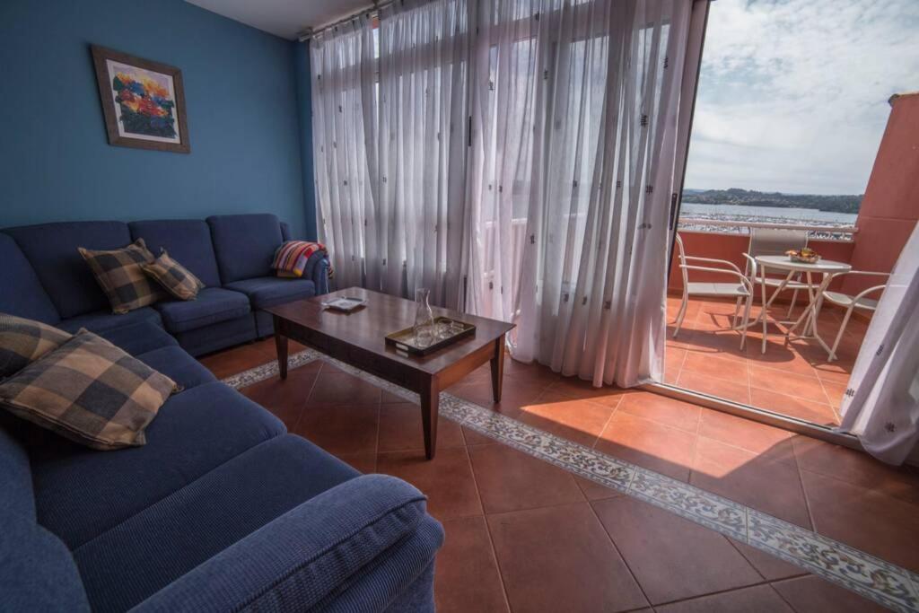 uma sala de estar com um sofá azul e uma mesa em Casa Morazón Fontán Sada em Sada