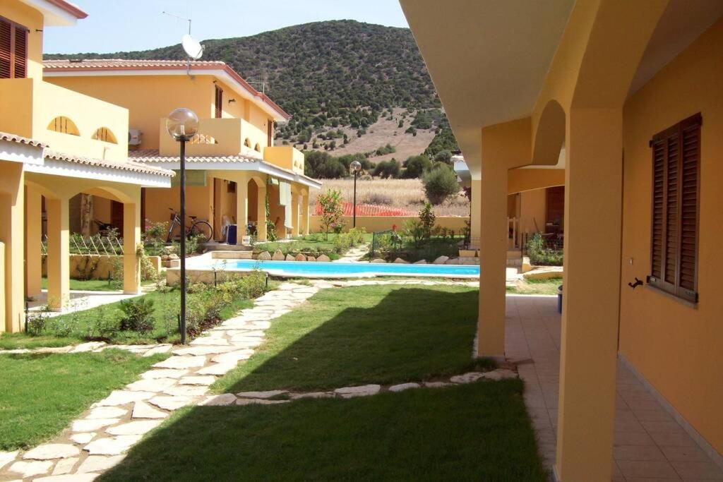 cortile di una casa con piscina di Villa su due livelli super accessoriata a SantʼAnna Arresi