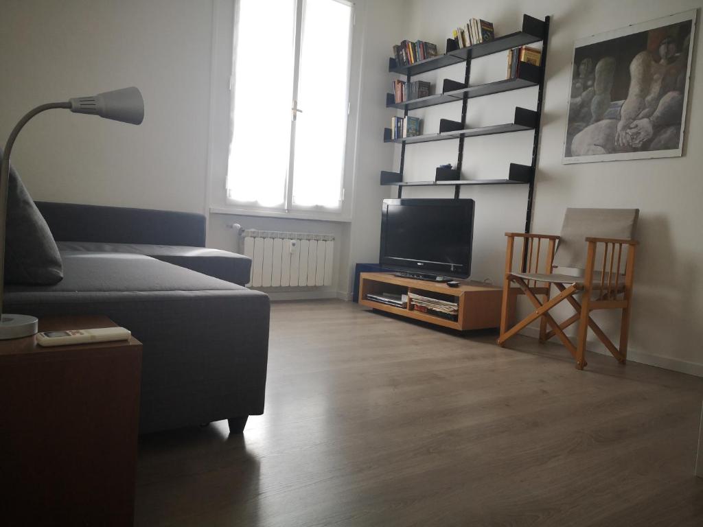 ein Wohnzimmer mit einem Sofa und einem TV in der Unterkunft Casa Valles in Triest