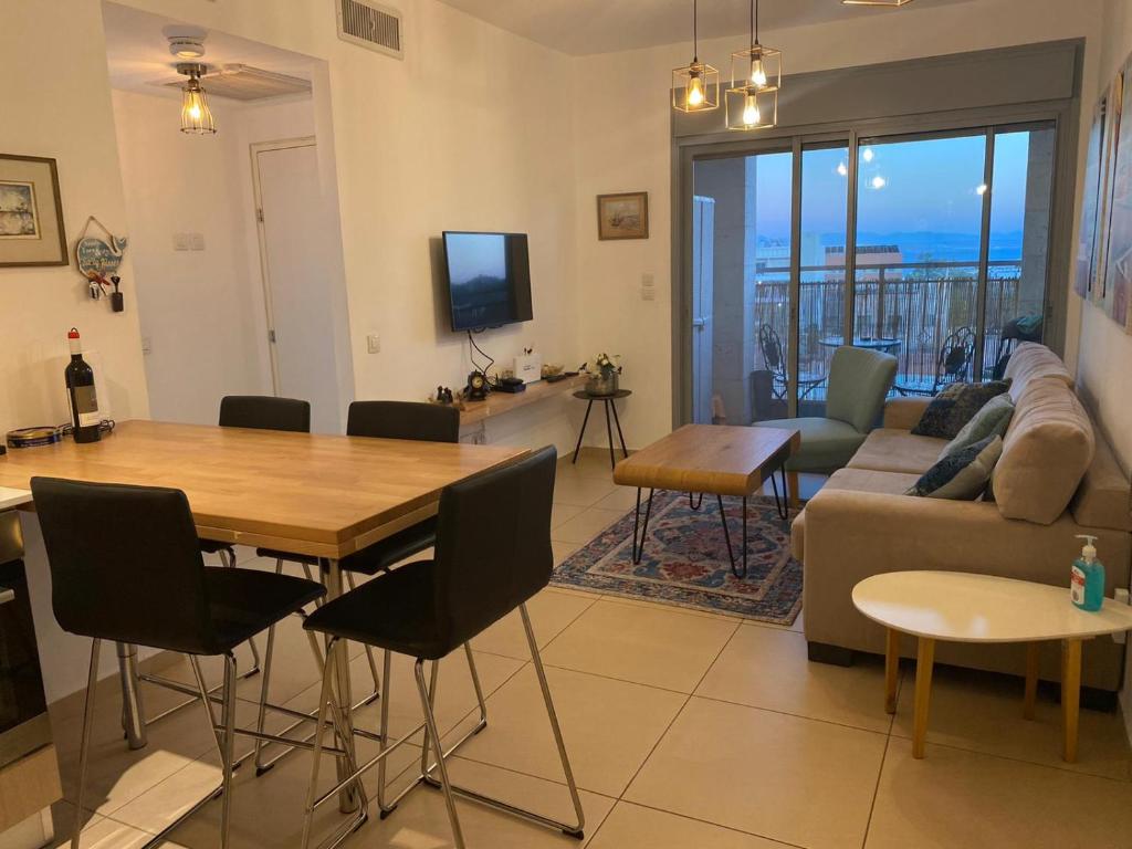 ein Wohnzimmer mit einem Tisch und einem Sofa in der Unterkunft Berger's Apartment in Eilat
