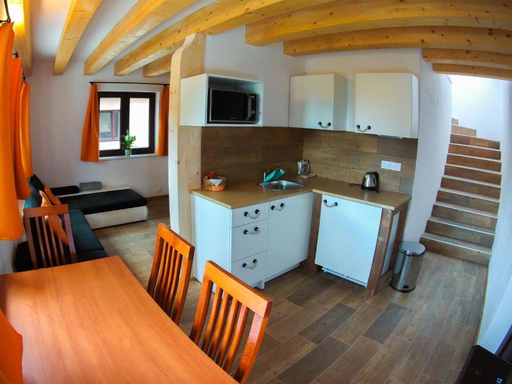 uma cozinha e sala de jantar com uma mesa e uma cozinha e um quarto em Apartmánový dům 13 Rodinný em Seč