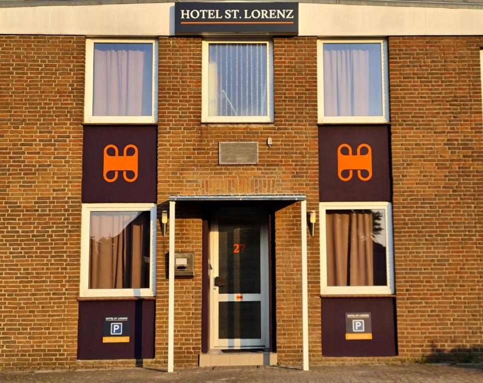 Hotel Sankt Lorenz في لوبيك: مبنى من الطوب عليه لافتات برتقالية