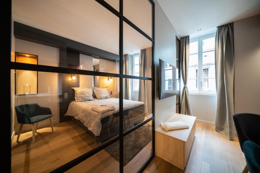 een slaapkamer met een bed en een glazen wand bij Le Luxury Design de la Vieille Ville in Annecy