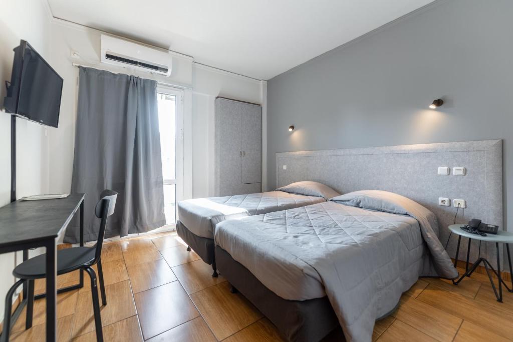 a bedroom with a large bed and a desk and a table at Stalis Hotel in Athens