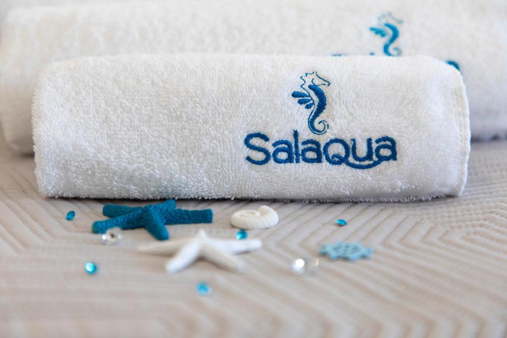 a towel on a bed with seashells and a towel at Salaqua Bed and Breakfast in Torre Mozza