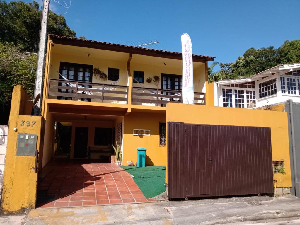 una casa amarilla con una puerta delante de ella en Pousada da Lagoa, en Florianópolis