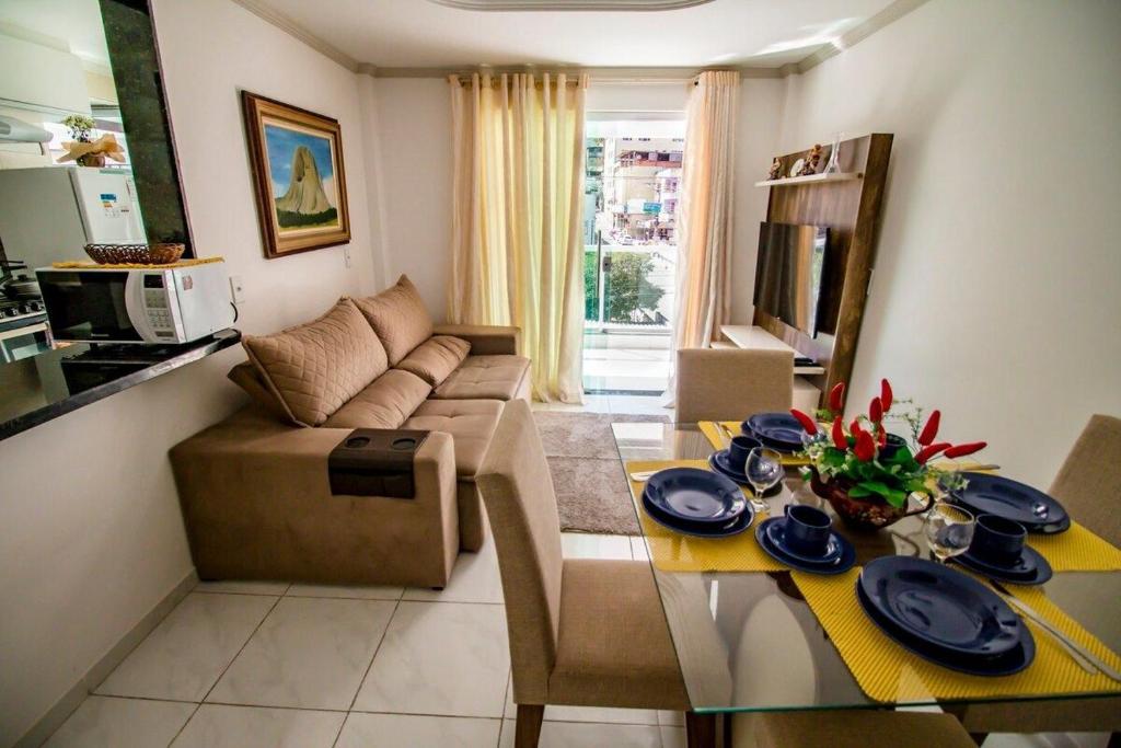 ein Wohnzimmer mit einem Tisch und einem Sofa in der Unterkunft Hospedagem Stein - Apartamento 101 in Domingos Martins