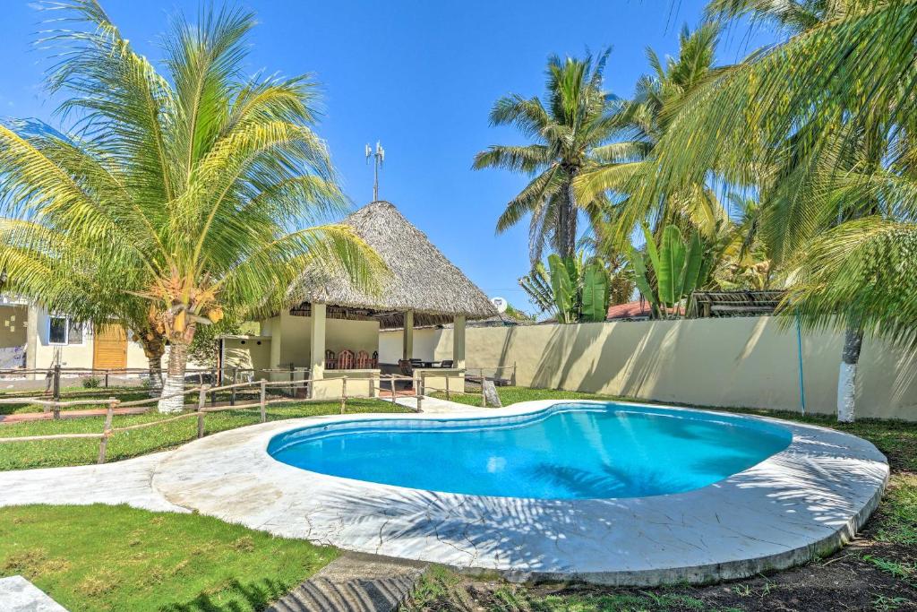 a swimming pool in front of a house with palm trees at Guatemala Beachfront Villa with Direct Beach Access! in Monterrico