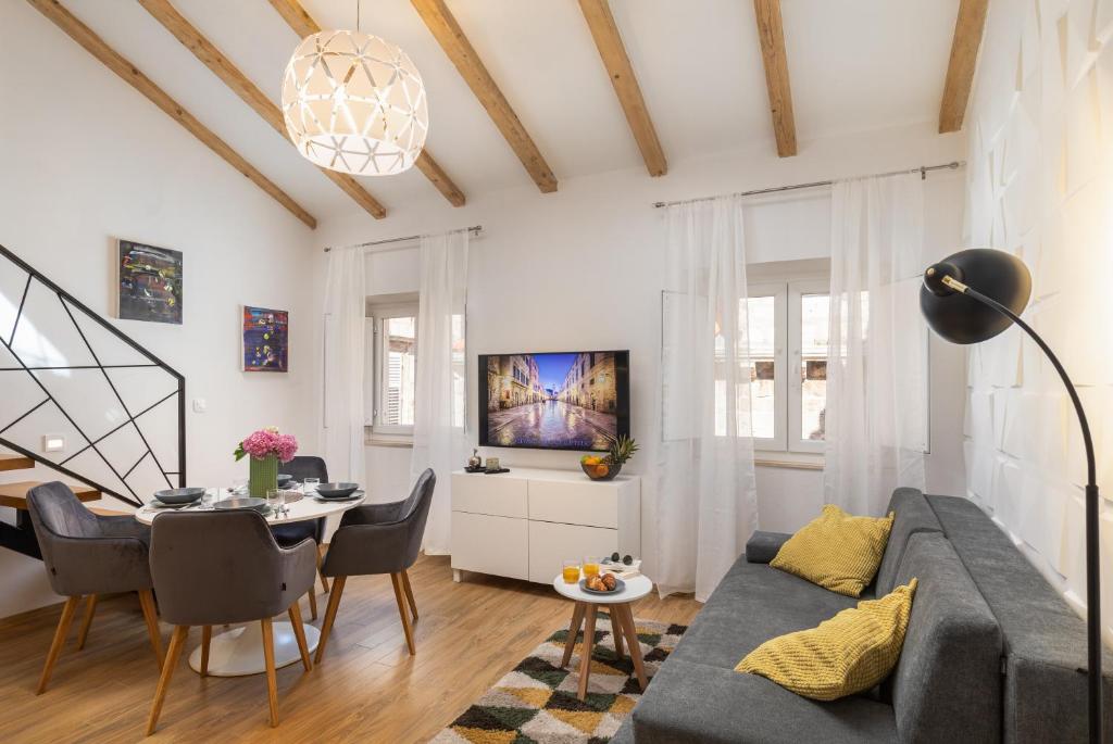 uma sala de estar com um sofá e uma mesa em GAMA Dubrovnik em Dubrovnik