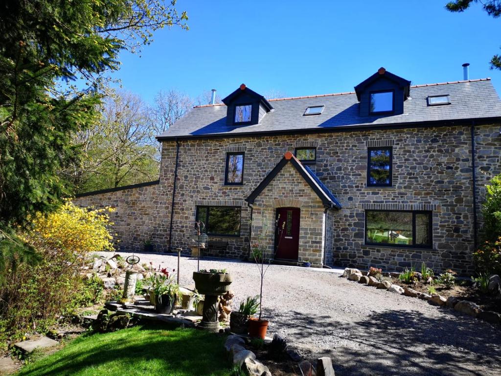 ein großes Backsteinhaus mit einer roten Tür in der Unterkunft Little London Bed & Breakfast and Glamping pod in Abercraf