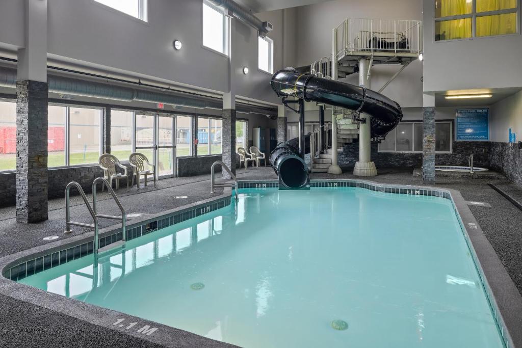 - une grande piscine avec toboggan dans un bâtiment dans l'établissement Home Inn & Suites Regina Airport, à Regina