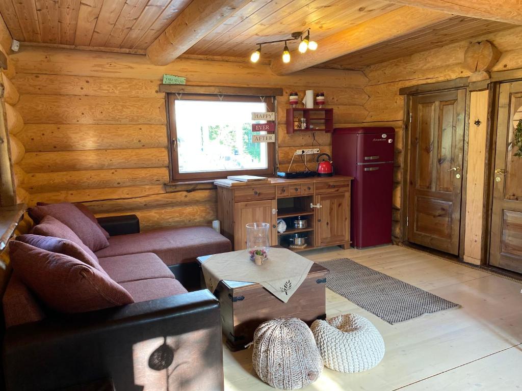 uma sala de estar com um sofá e uma mesa numa cabina em Laane Talu Sauna House em Uhtjärve