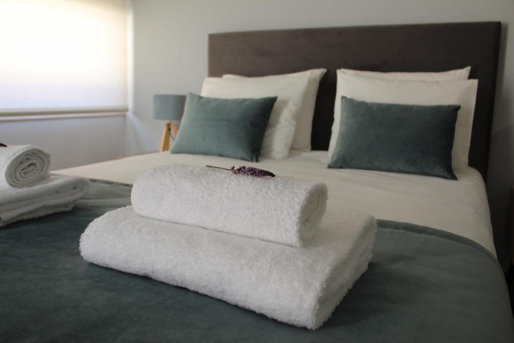 Una cama blanca con dos almohadas encima. en Alojarte, en Figueiros