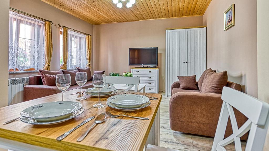 een woonkamer met een tafel met wijnglazen bij Apartmány v Novém Městě pod Smrkem in Nové Město pod Smrkem