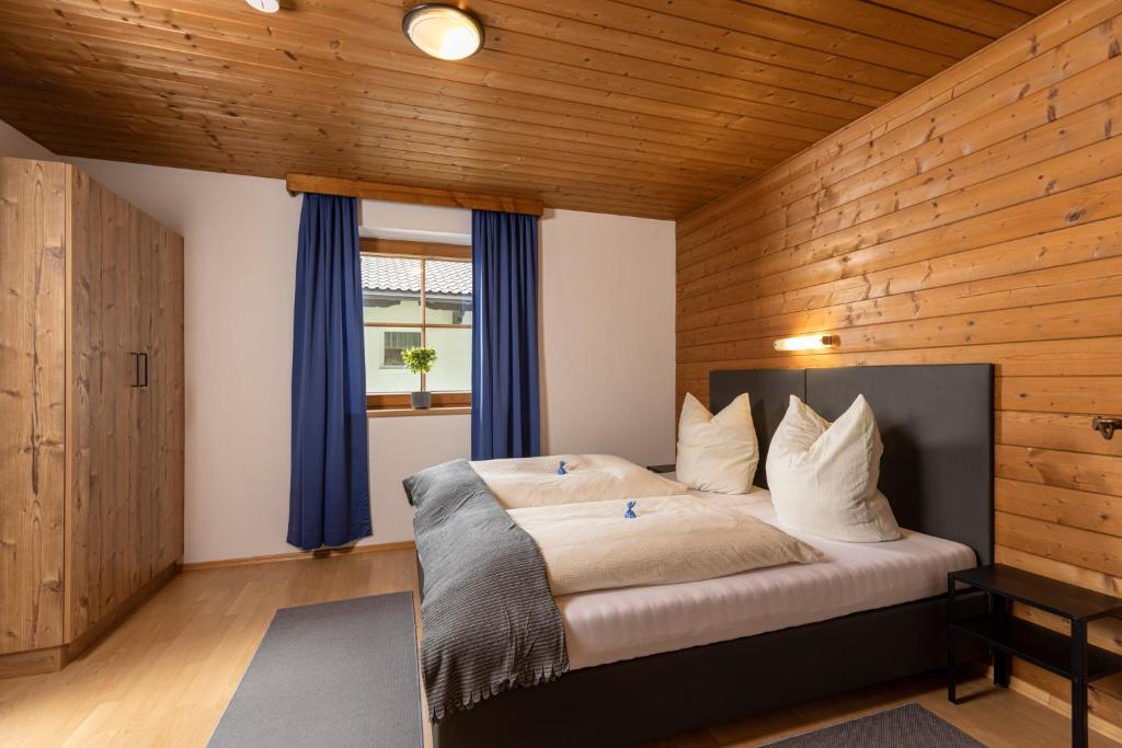 a bedroom with a large bed with blue curtains at Ferienhaus Anna in Zell am Ziller