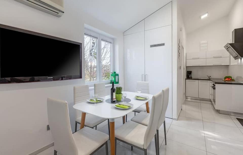 Apartment Betty في بارباريغا: غرفة طعام بيضاء مع طاولة بيضاء وكراسي