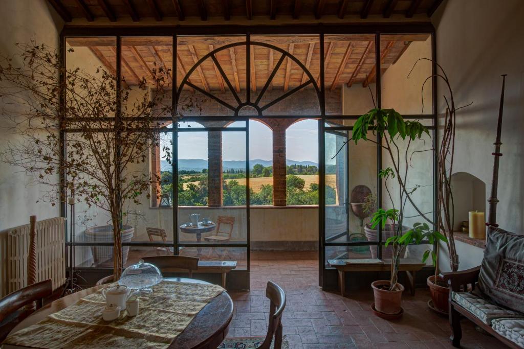 a room with a table and chairs and a large window at Palazzo Luci in Colle di Val d'Elsa