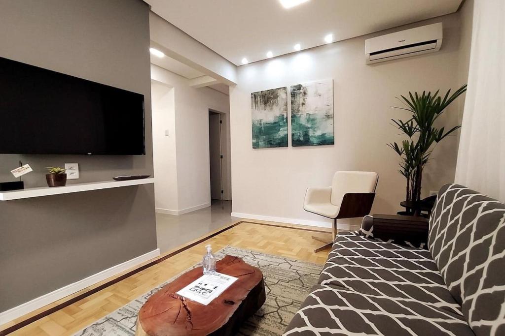 un soggiorno con divano e TV a schermo piatto di Apartamento Aluri a Porto Alegre