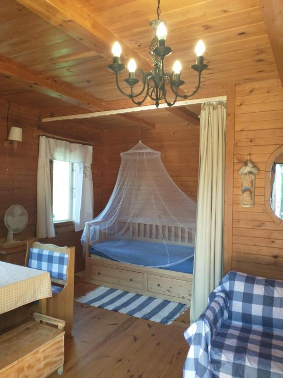 1 dormitorio con 1 cama en una cabaña de madera en Chabrowa Chatka en Supraśl