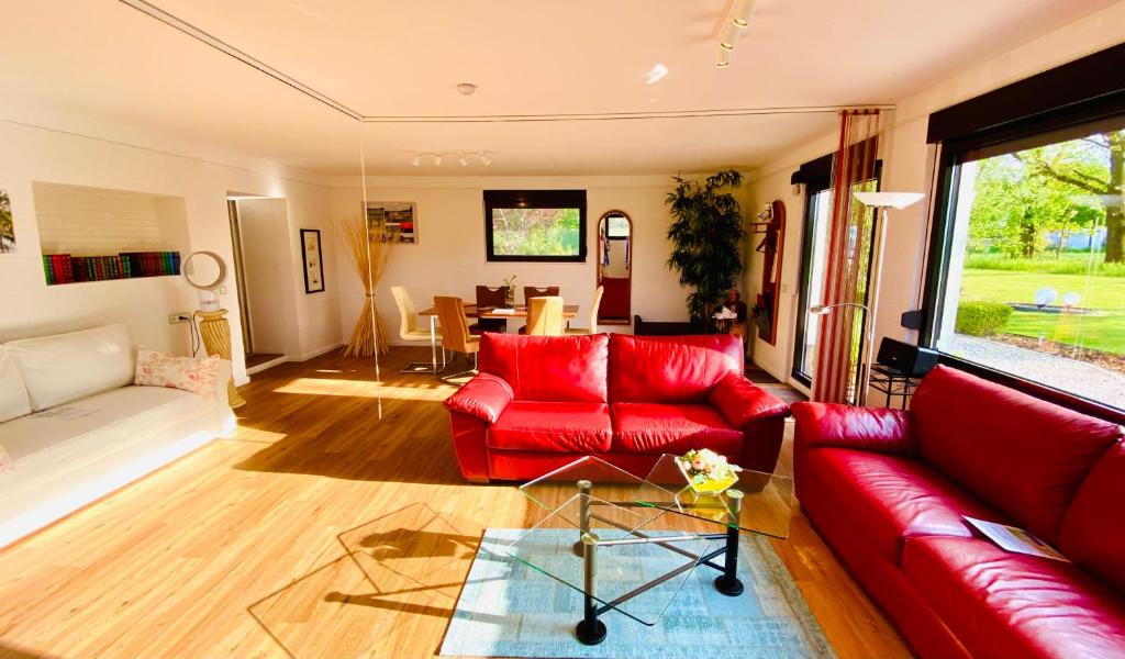 una sala de estar con sofás rojos y una mesa. en Premium Ferienwohnung Ulf-Dieter Kunstmann, en Kremmen