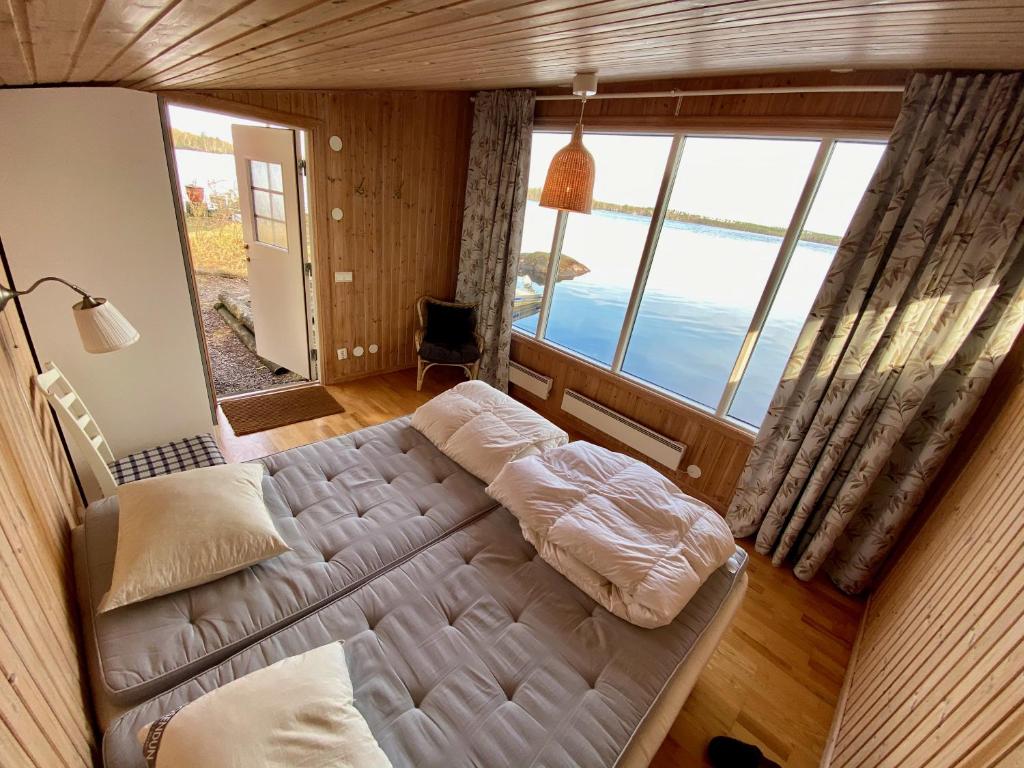 a bedroom with a bed and a large window at "Talludden" by the lake Årydssjön, in Furuby