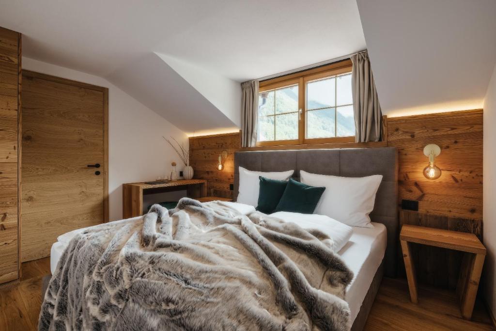 a bedroom with a bed with a blanket at Ludwig‘s Mountain Lodges in Dalaas