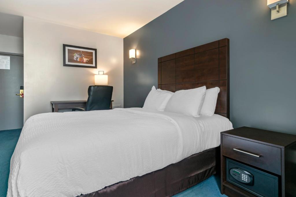Cette chambre comprend un grand lit et une chaise. dans l'établissement Econo Lodge, à Montréal