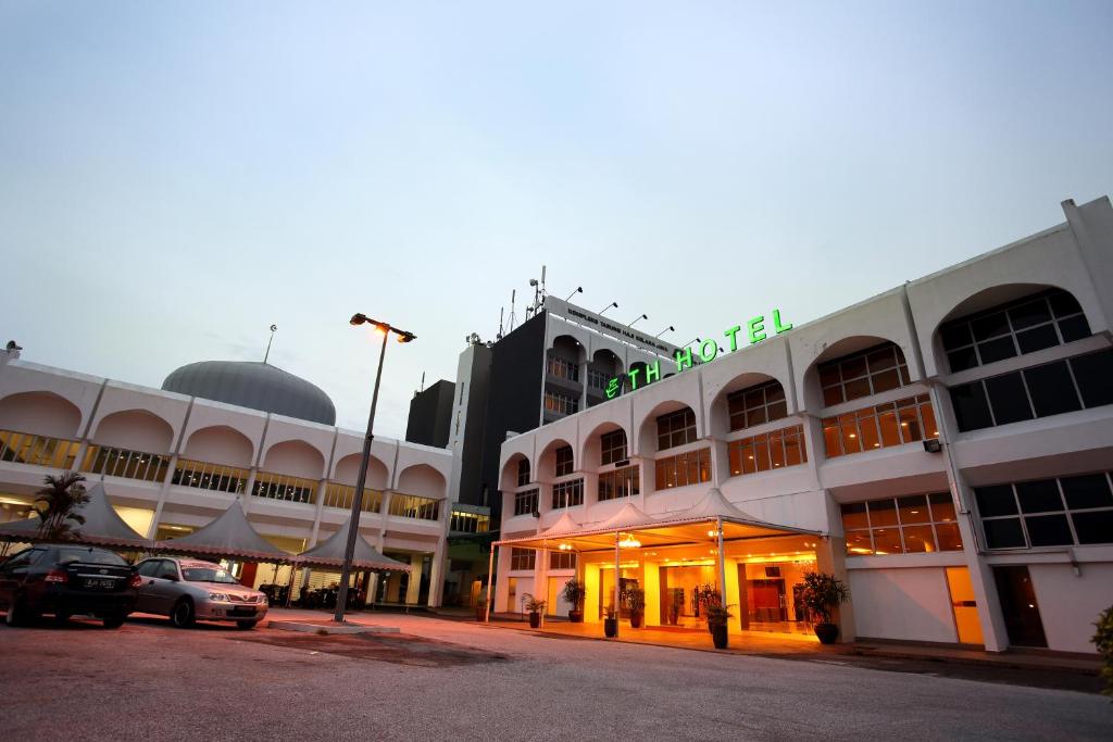 un grand bâtiment avec des voitures garées devant lui dans l'établissement TH Hotel Kelana Jaya, à Petaling Jaya