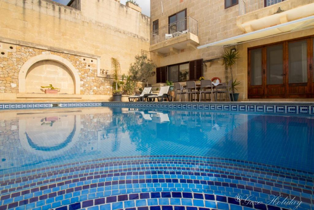 a swimming pool in front of a house at Villa Mandolina in Għarb