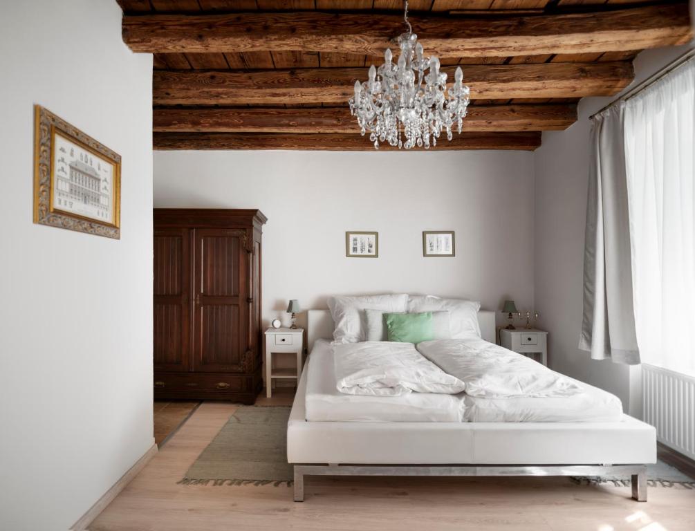 肖普朗的住宿－Florand Rooms&Wine，卧室配有白色的床和吊灯。
